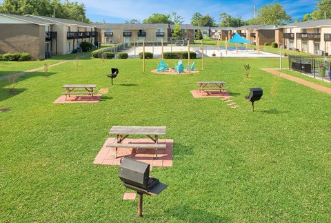 A playground with a slide and picnic tables.