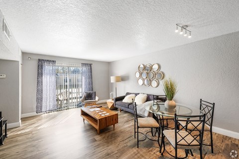 A living room with a glass table and chairs, a sofa, and a coffee table.