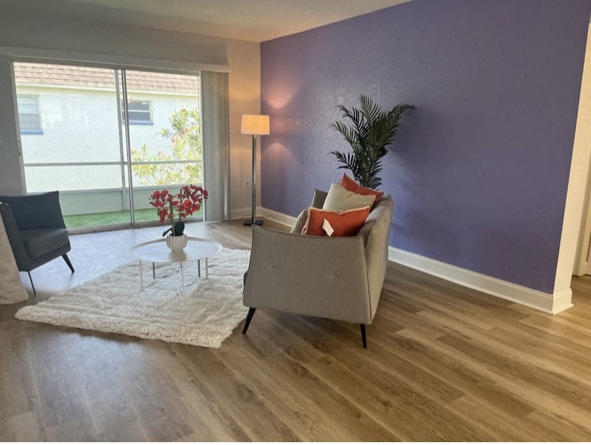 a living room with purple walls and a large window