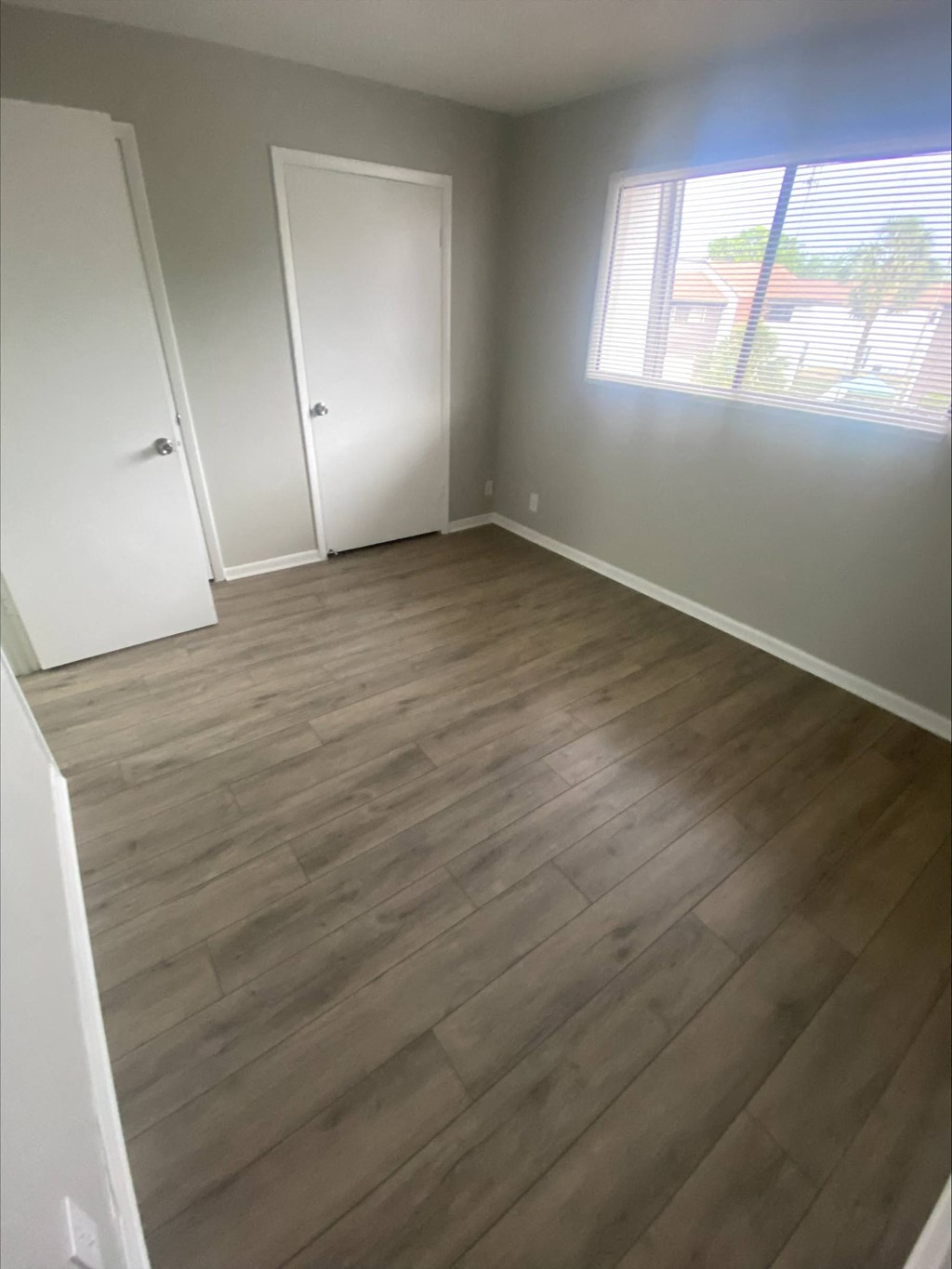 an empty room with a window and a closet