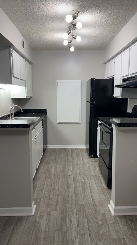 Updated kitchen with black appliances and white cabinets.