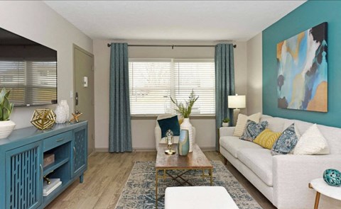 A living room with a white couch, a blue cabinet, and a painting on the wall.