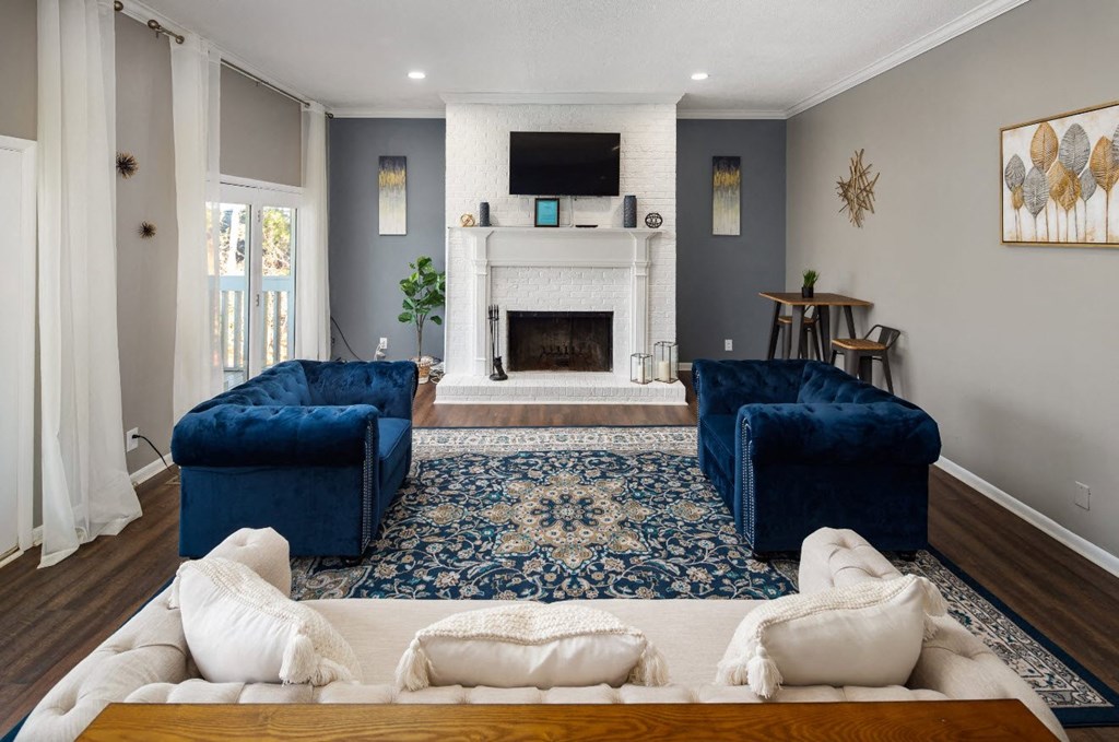 a living room with two blue couches and a fireplace