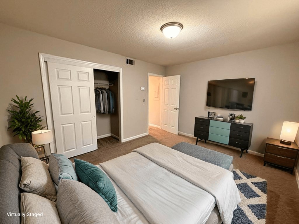 A bedroom with two beds and a dresser with a mirror above it.