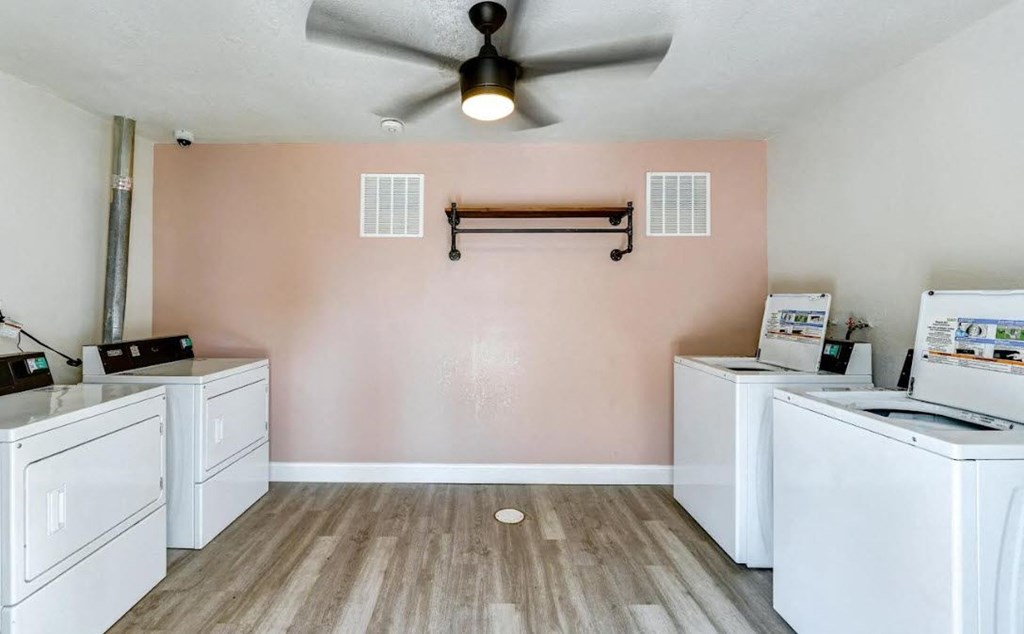 a kitchen with white appliances and a ceiling fan