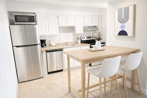 A kitchen with a table and chairs.