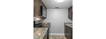 A kitchen with granite countertops and wooden cabinets.