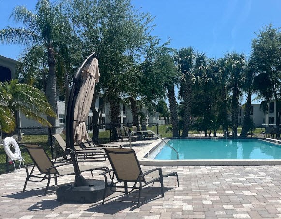 a pool with chairs and an umbrella next to it