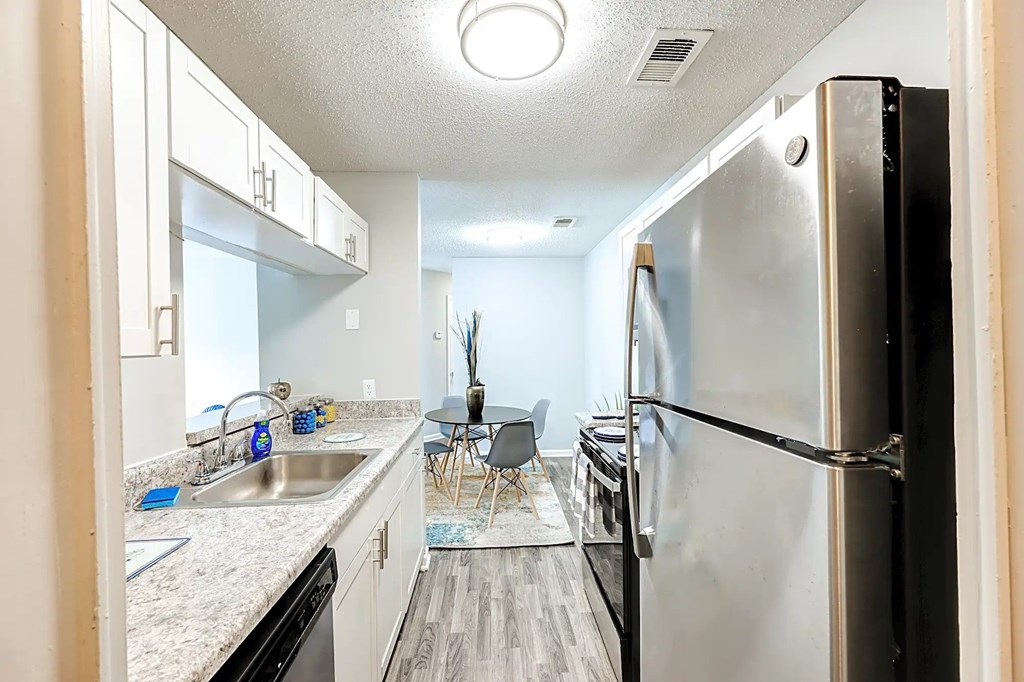 A kitchen with a black refrigerator and white cabinets. A kitchen with a black refrigerator and white cabinets at Sedgefield Square Apartments, North Carolina, 27407
