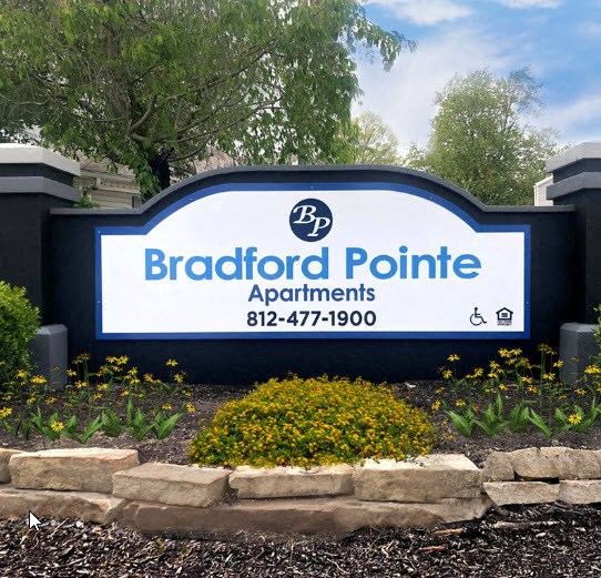 a sign pointe apartments in front of a garden