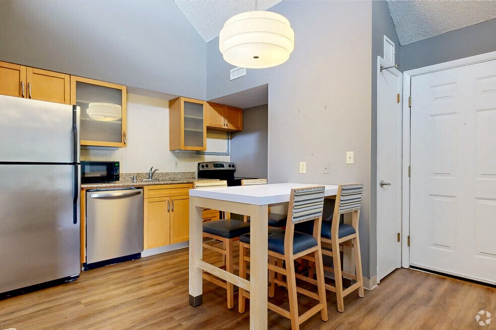 A kitchen with a table and chairs.