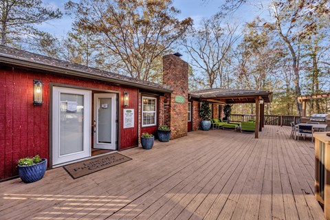 a patio with a brick building and a wooden deck