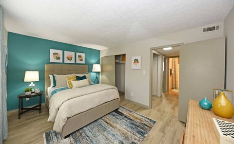 A bedroom with a large bed and a blue wall.