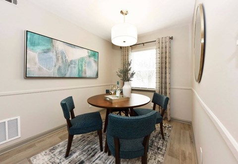 A dining room with a round table and chairs.