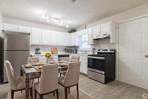 A modern kitchen with a dining table set for four.