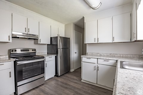 A kitchen with white cabinets and a stainless steel refrigerator.