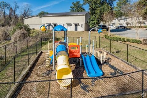 A playground with a yellow slide and a blue slide.