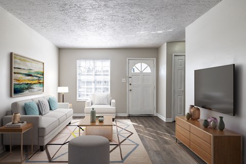 A living room with a white couch, a coffee table, and a painting on the wall.