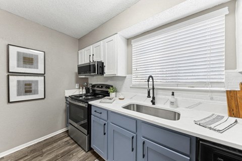 the kitchen of our studio apartment atrium with stainless steel appliances and white cabinets