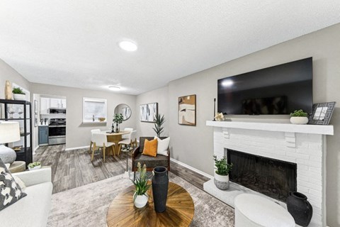 A living room with a fireplace and a television on the wall.