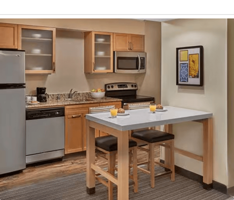 A kitchen with a table and chairs and a fridge.