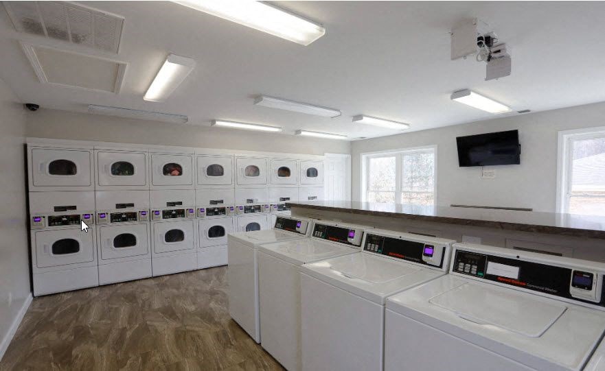 a laundry room with washers and dryers and a row of washing machines