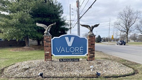 A sign that says Valore stands in front of a road.