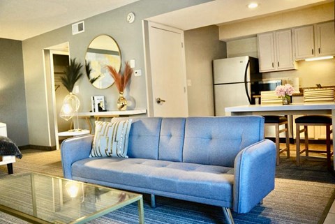 A blue couch is in the middle of a living room.