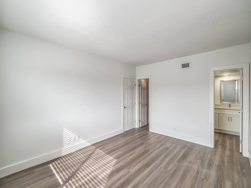 an empty living room with white walls and wood floors