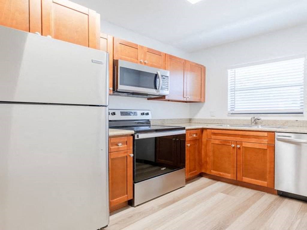 a kitchen with white appliances and wooden cabinets