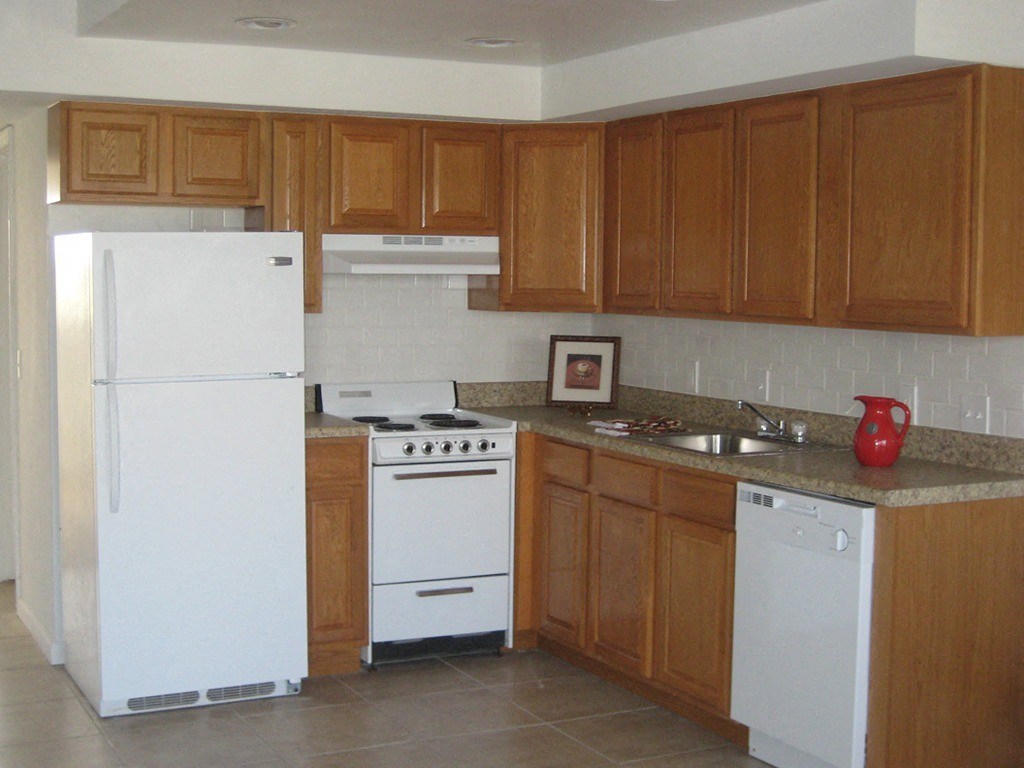 a kitchen with white appliances and wooden cabinets
