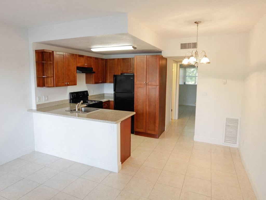 an empty kitchen with a sink and a refrigerator