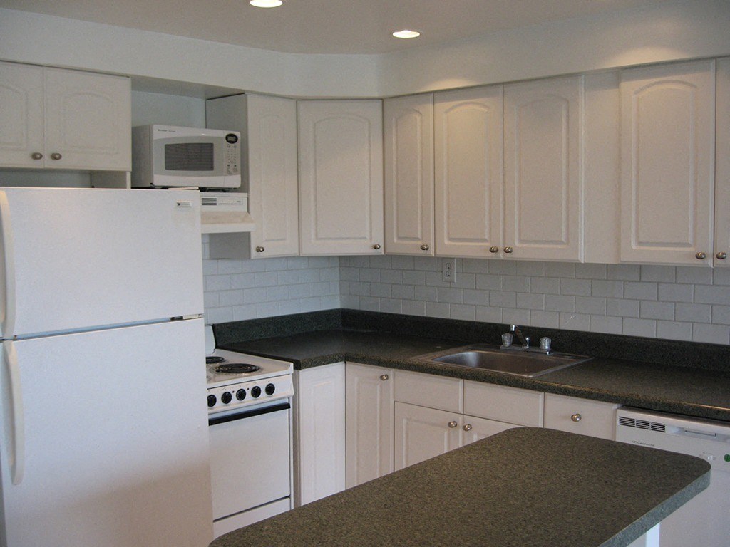 a white kitchen with white appliances and white cabinets