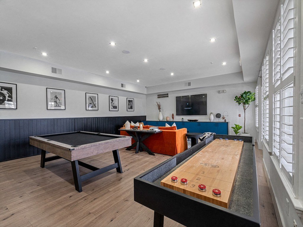 a game room with a shuffleboard table and a pool table
