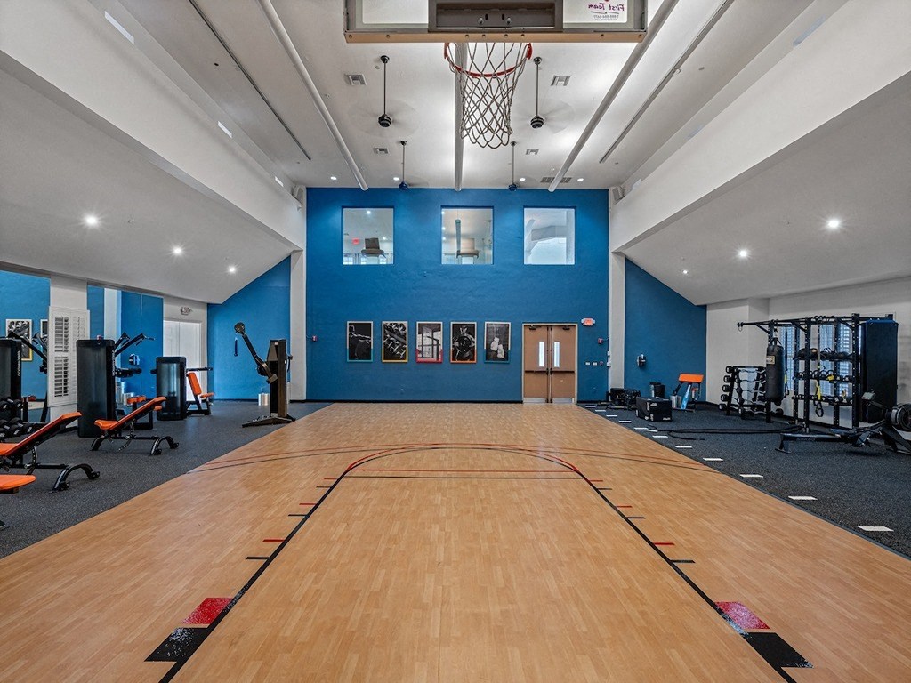 a basketball court in a gym with a basketball hoop and gym equipment