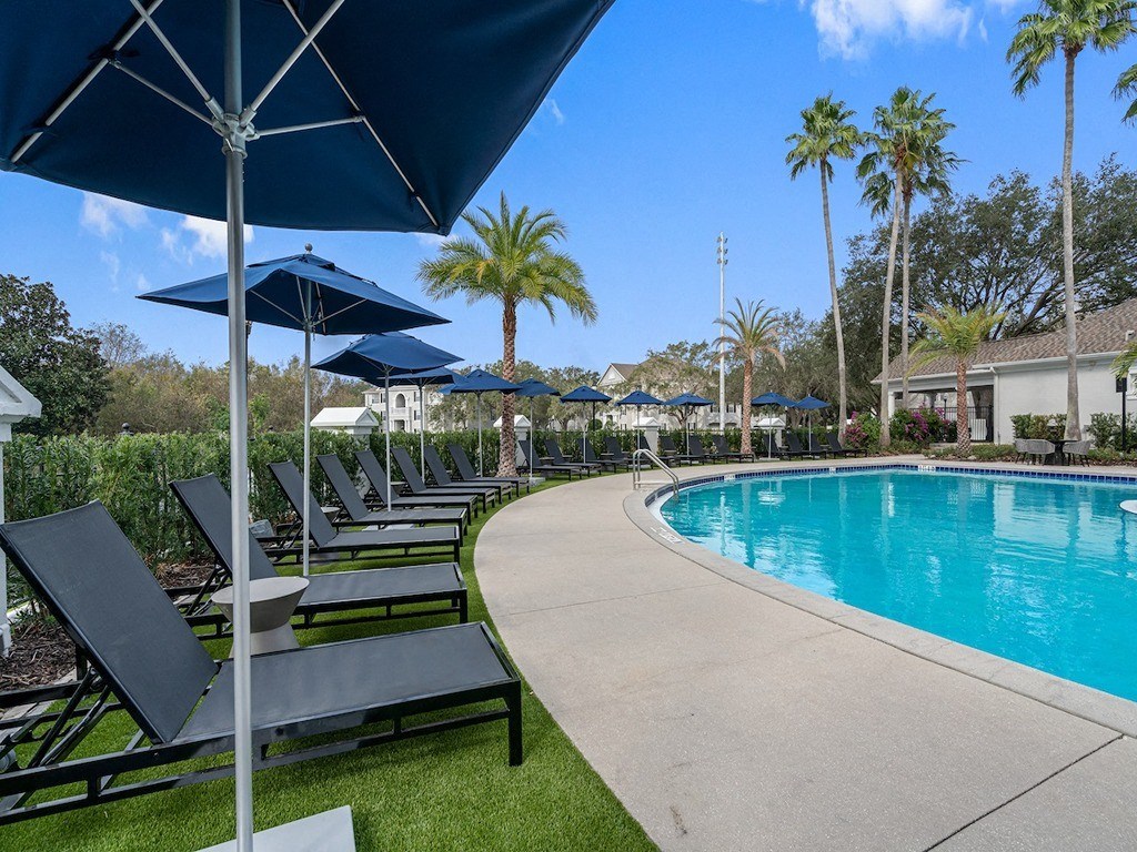 a swimming pool with lounge chairs and umbrellas at the resort