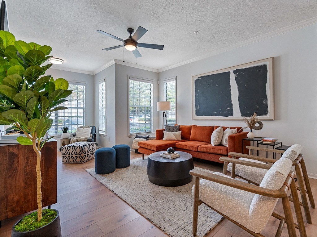 a living room with a orange couch and a ceiling fan