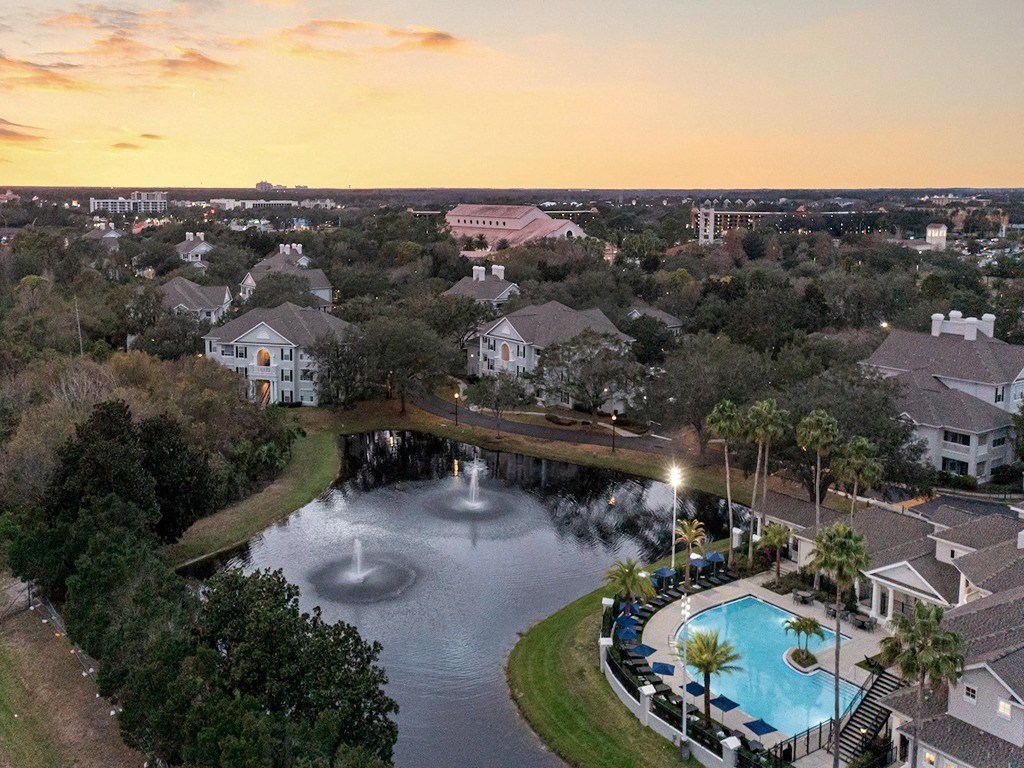 an aerial view of a swimming pool and fountain at sunset