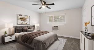 A bedroom with a bed, nightstand, and a ceiling fan.