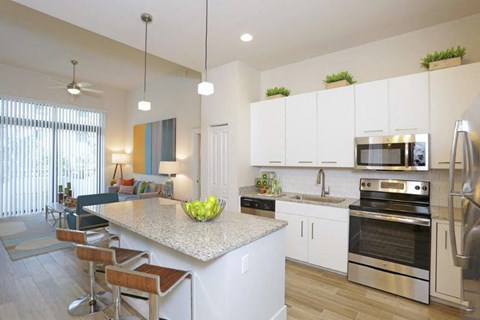 a kitchen and living room with a marble counter top