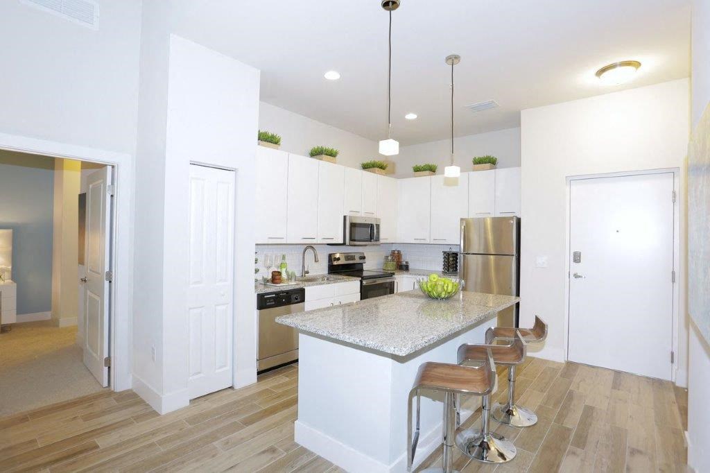 a kitchen with an island and a stainless steel refrigerator