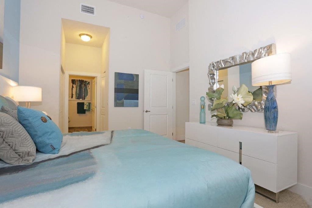 a bedroom with a bed and a dresser and a mirror