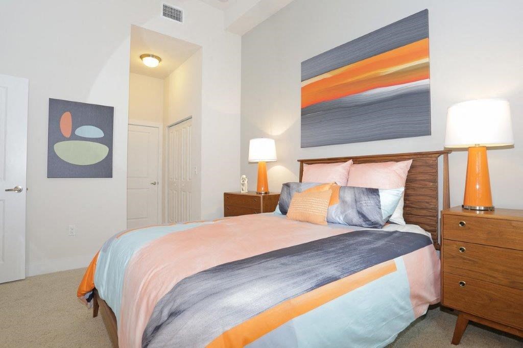 a bedroom with a bed and a painting on the wall