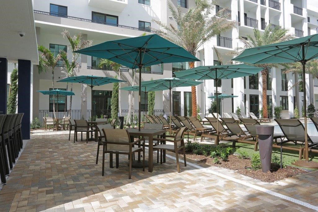 a patio with tables and chairs and umbrellas