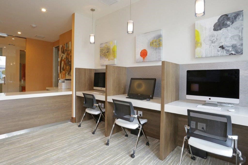 a conference room with desks and chairs and paintings on the wall
