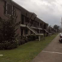 A car is parked on a street in front of a building.
