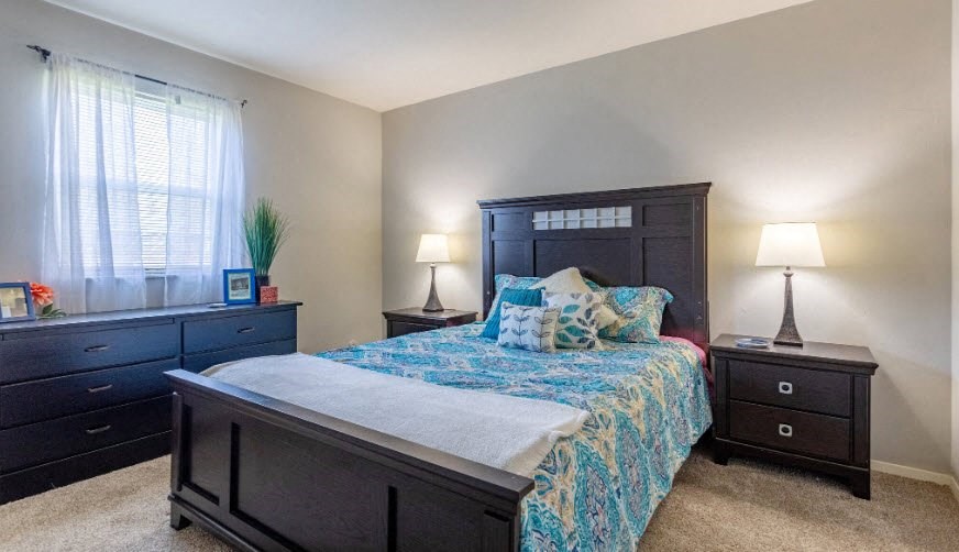 a bedroom with a bed and two dressers