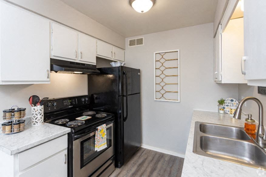 a kitchen with a stove refrigerator and sink