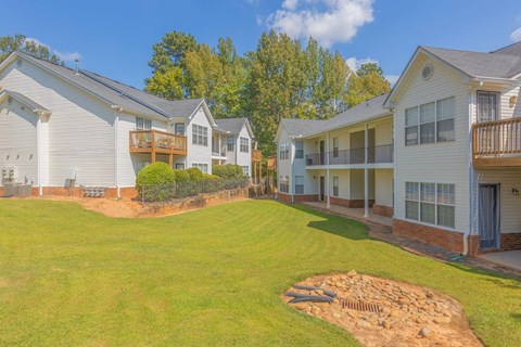 A row of houses with a green lawn in front.