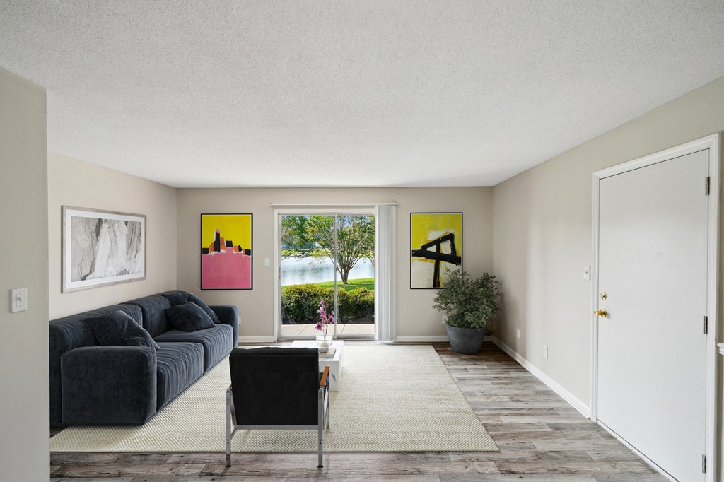 a living room with a blue couch and a white rug and a sliding glass door